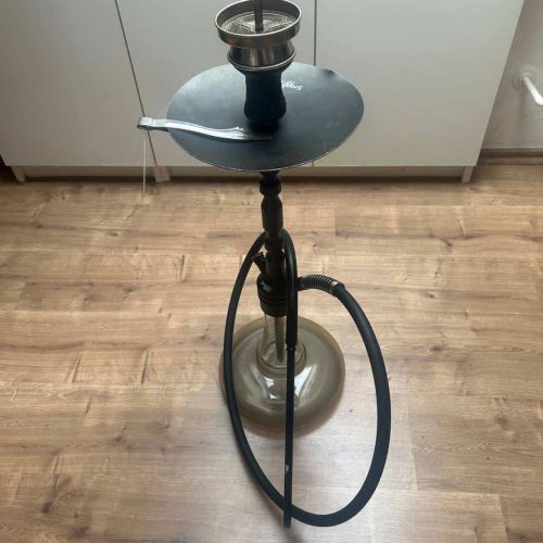 Rauchsäule auf einem kleinen Tisch mit Shisha-Setup, inklusive Schlauch und Kopf.