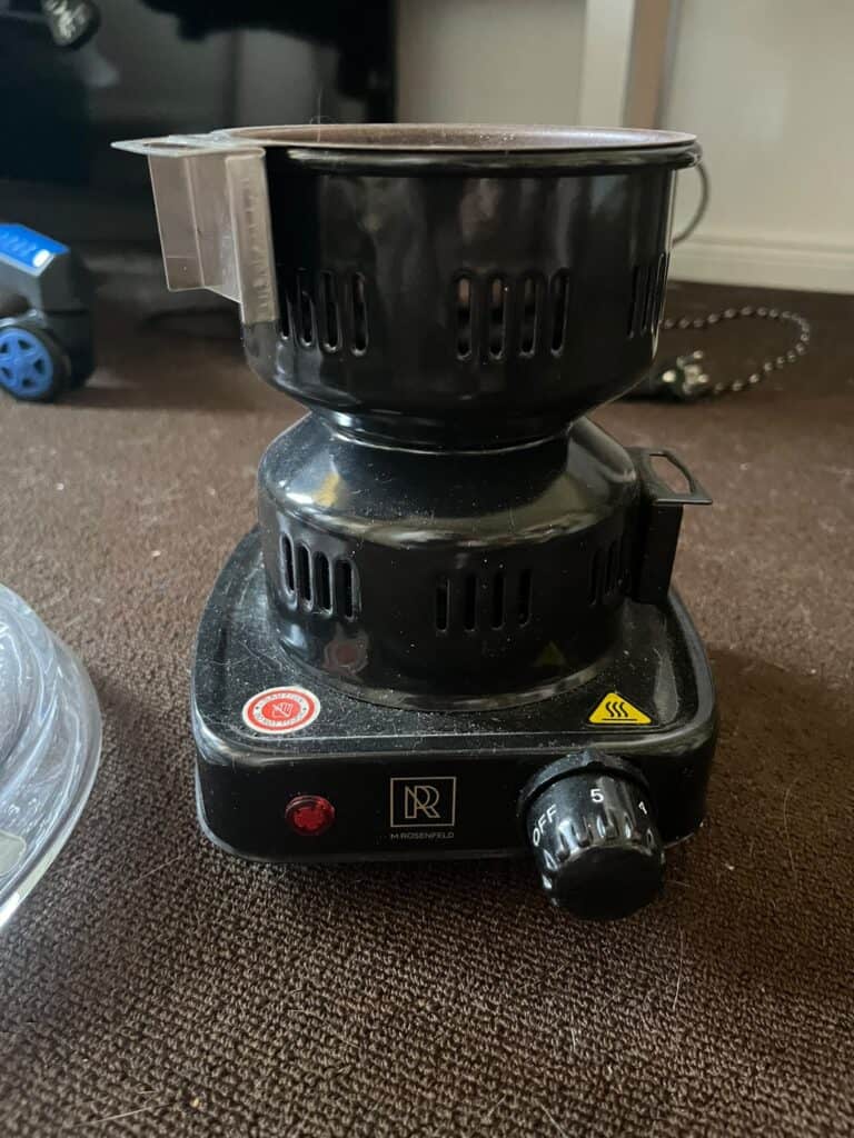 Elektrischer Shisha-Ofen mit schwarzer Glasbowl und Temperaturregler.