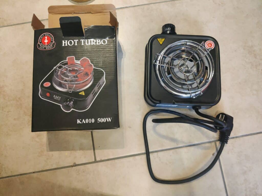Kleiner elektrischer Heizlüfter mit Kabel und Schutzgitter.