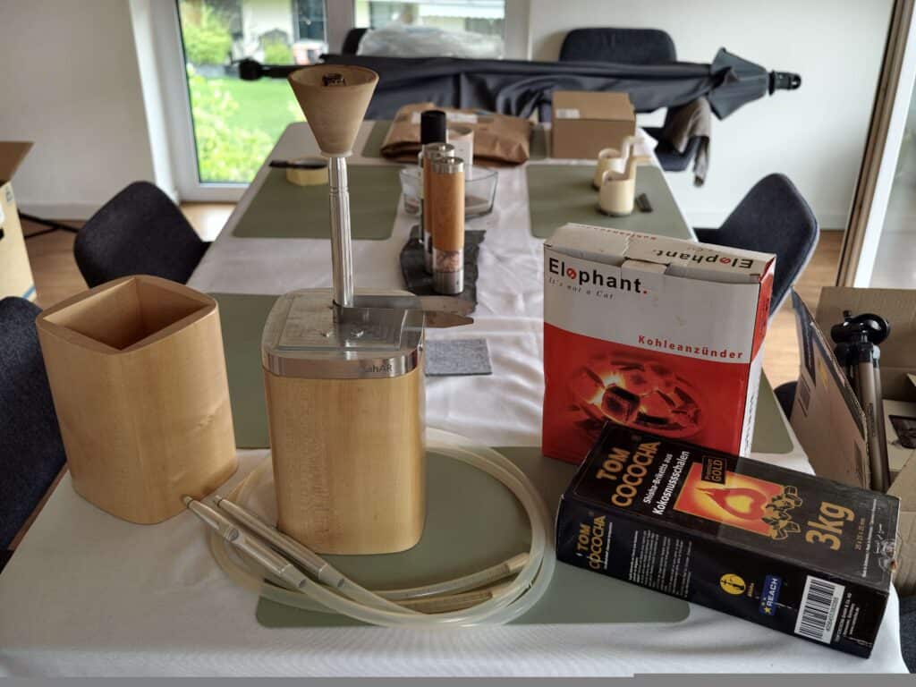 Verschiedene Shisha-Teile und Zubehör auf Esstisch.