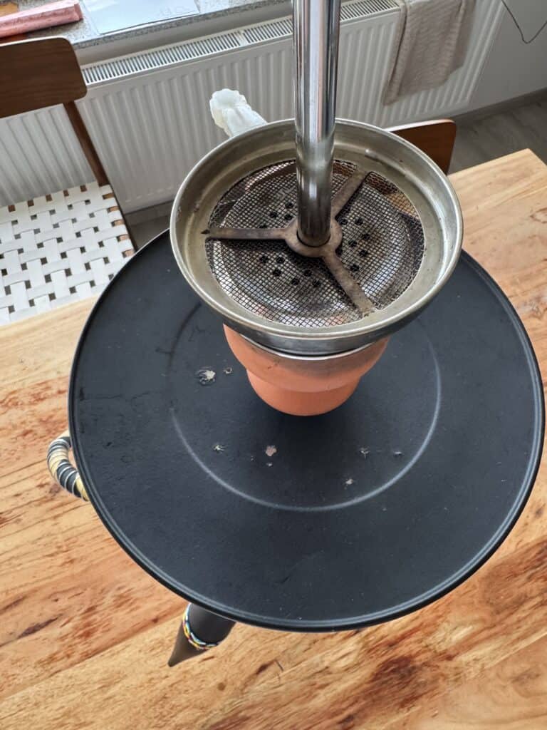 Shisha mit Metallkopf und Tabak, bereit zum Rauchen.