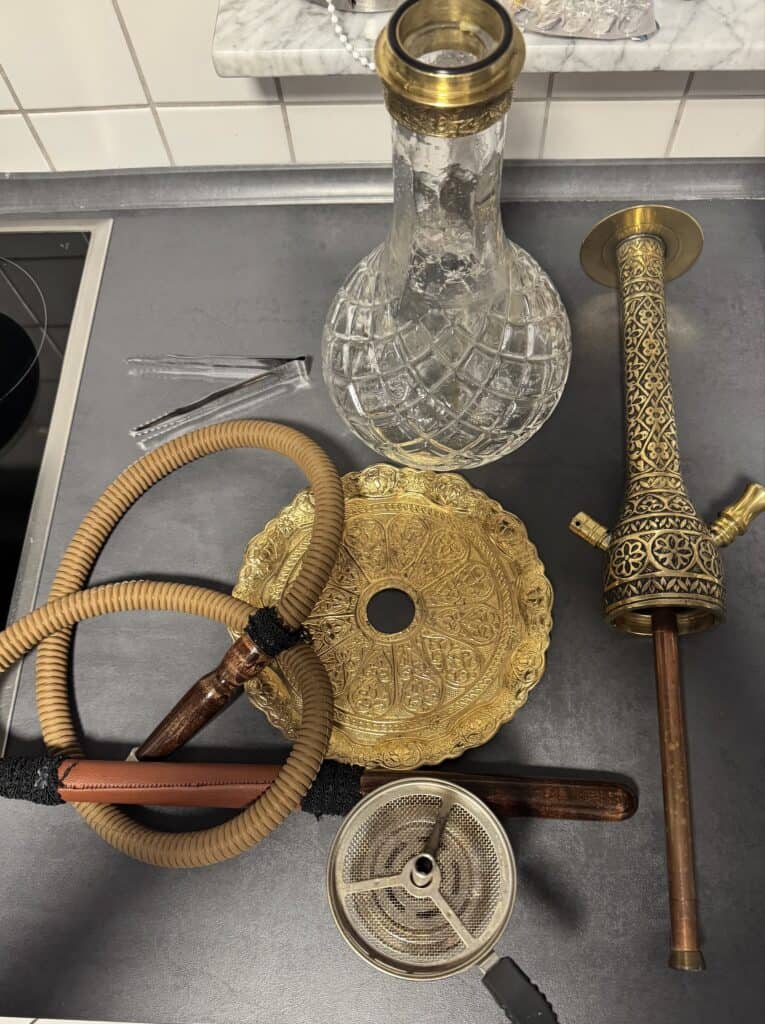 Verschiedene Shisha-Teile inklusive Glasbowl und Schlauch.