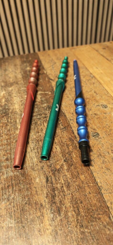 Drei bunte Shisha-Hookah-Knüppel auf Holzoberfläche.
