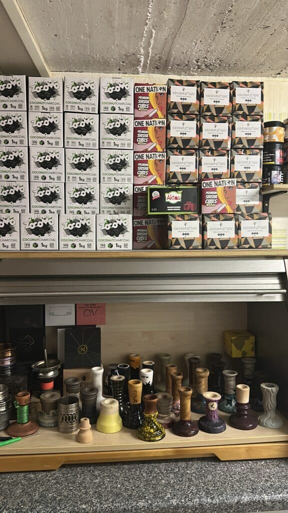 Verschiedene Shisha-Glasbowl und Zubehör im Verkaufsregal.