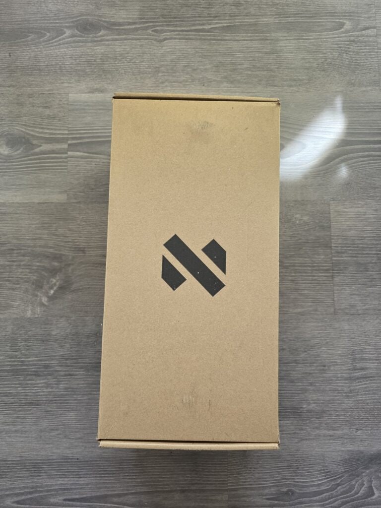 Produktverpackung mit schwarzem Logo auf braunem Karton.