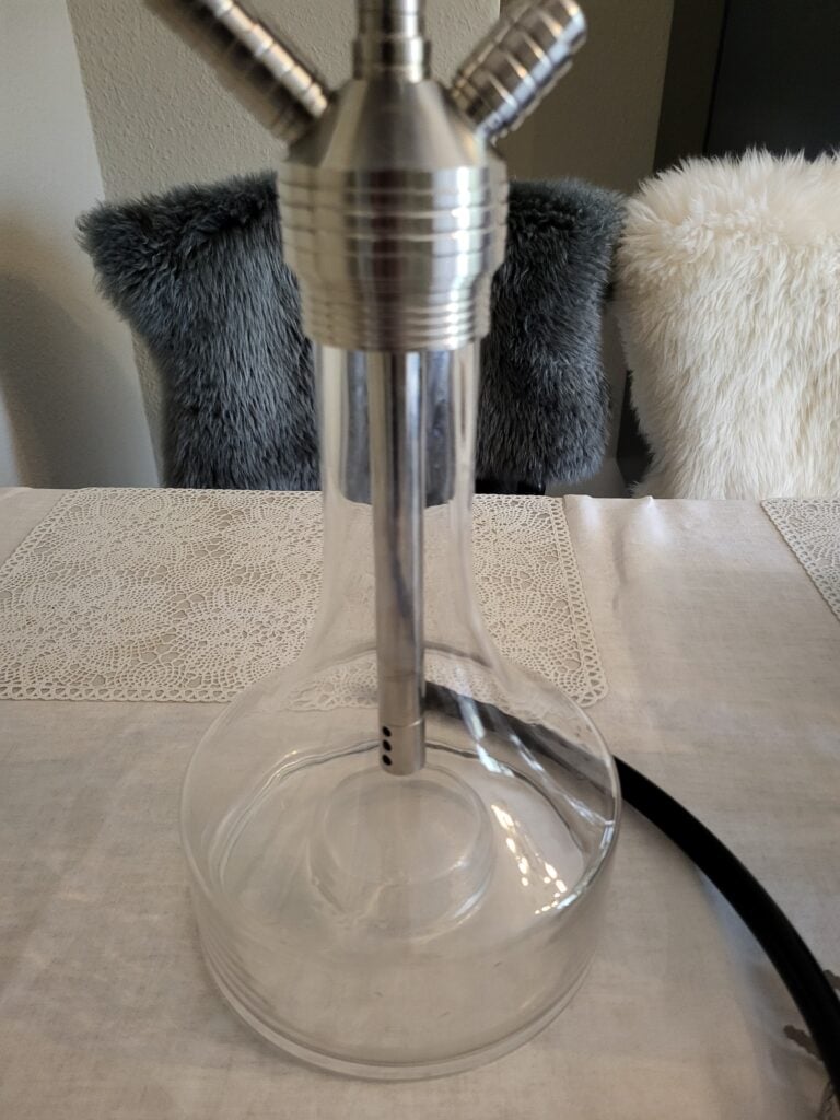 Stilvolle Shisha mit Metallrohren und Glasbowl auf Tisch.