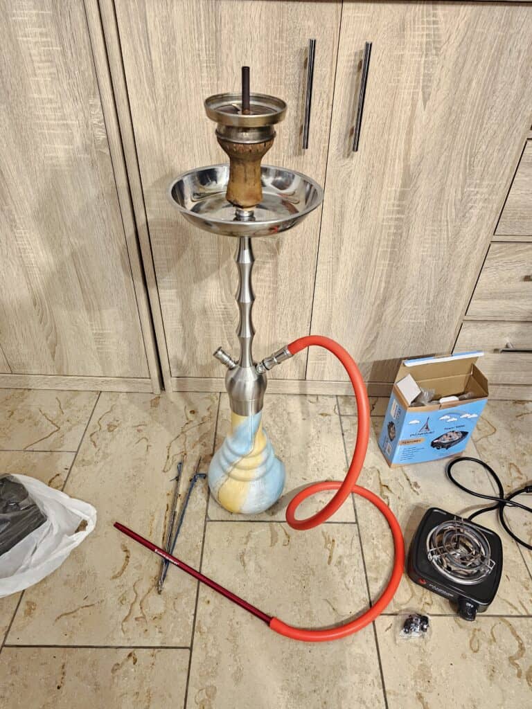Shisha mit Wasserpfeife, Schlauch und Kohle, bereit zum Rauchen.