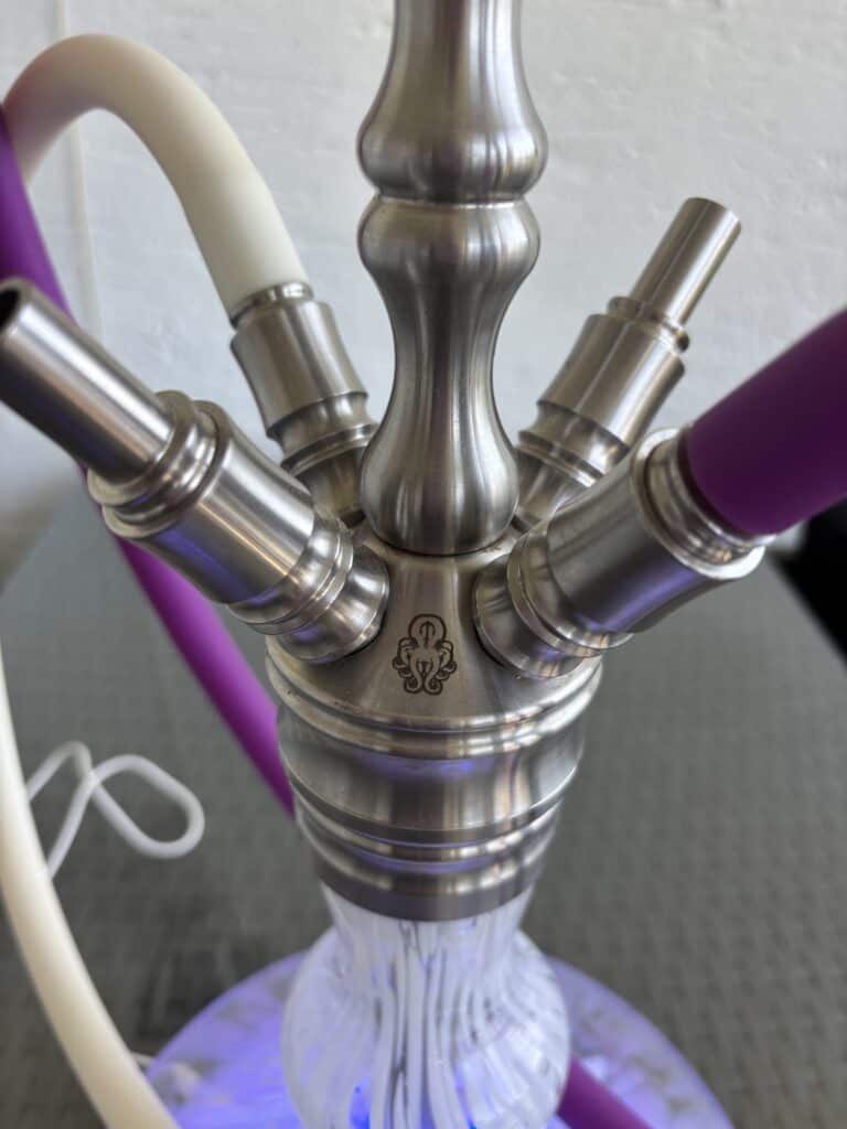 Schwarze Shisha mit bunten Schläuchen, Metall- und Glasdetails, ideal für Wasserpfeifenliebhaber.
