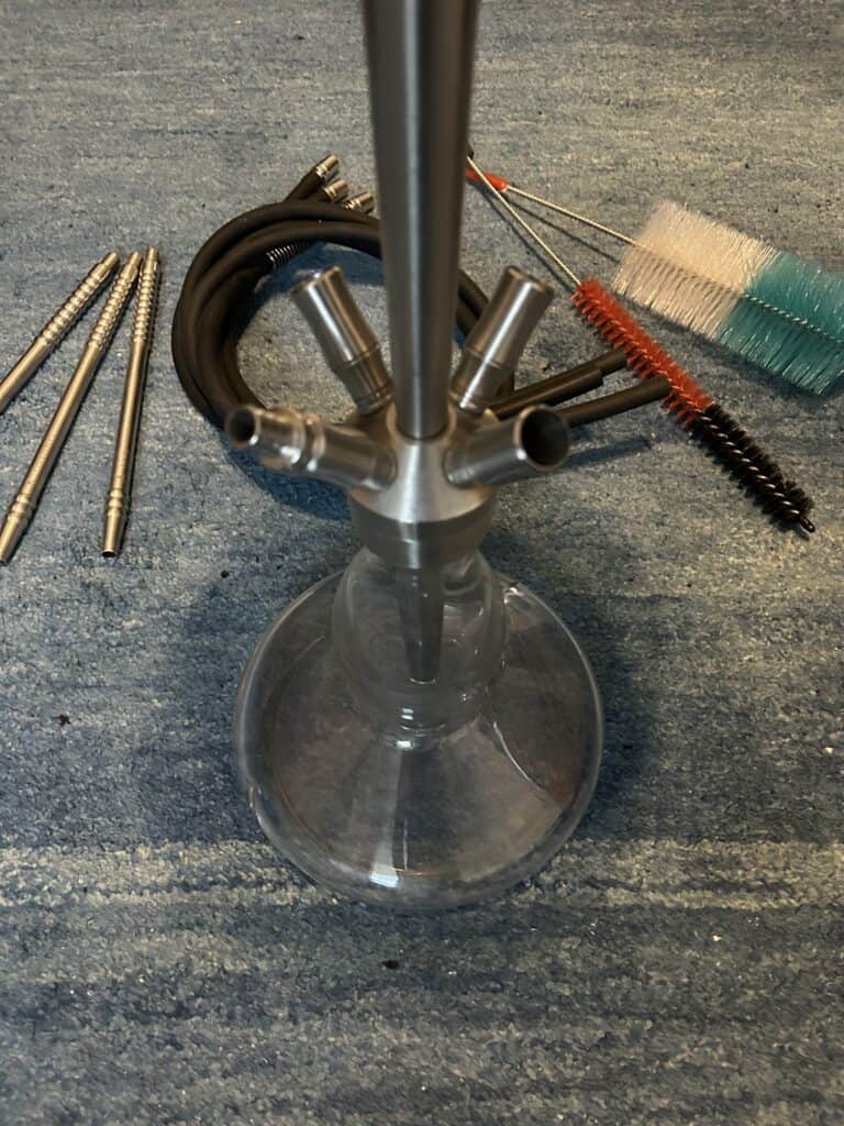 Shisha-Zubehör mit Glasbowl, Schlauch und Reinigungsbürsten.