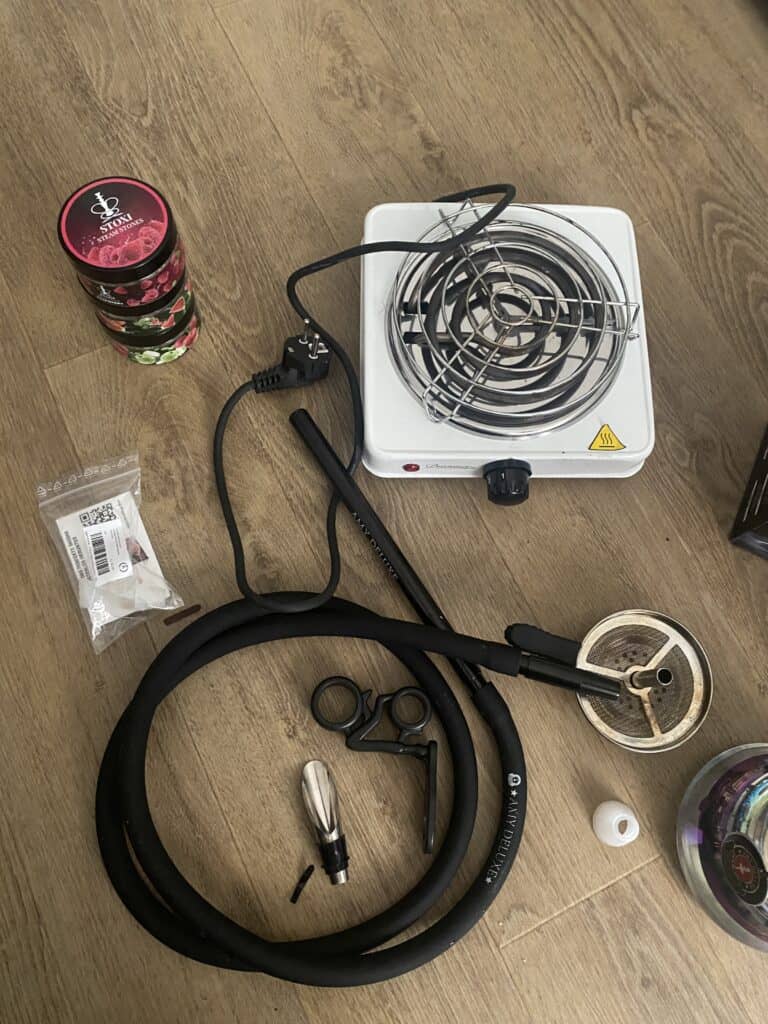 Shisha mit Heizplatte, Schlauch und Tabak in Verpackung.