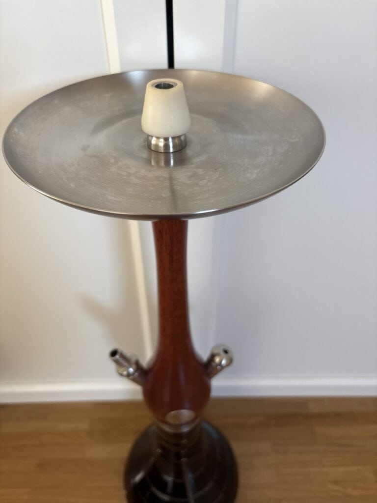 Shisha-Tabakständer mit Metallplatte und Holzstamm.