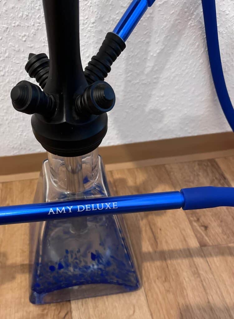 Blick auf eine blaue Shisha-Glasbowl mit Silikonschlauch und schwarzem Kopf.