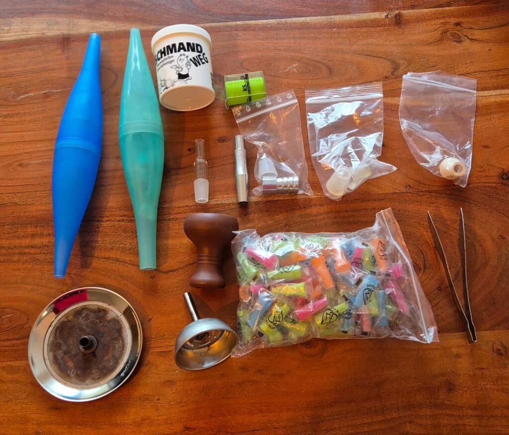 Verschiedene Werkzeuge und Reinigungsmittel für Shisha-Pflege.