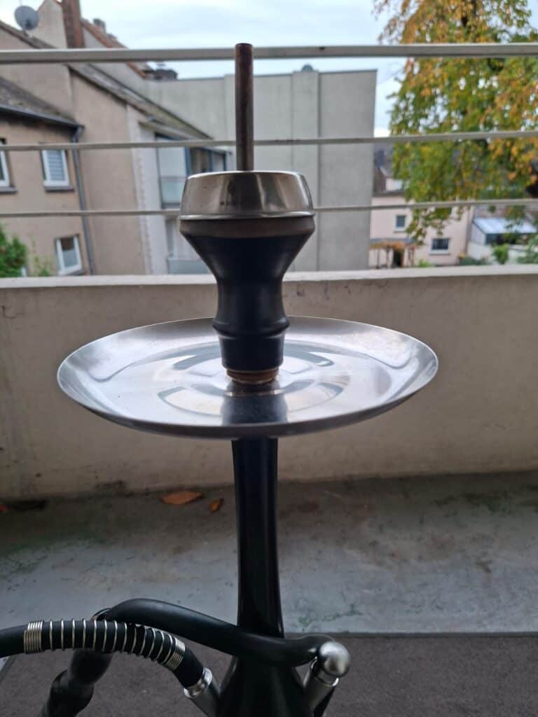 Shisha mit Metallkopf und Glasteller, bereit zum Rauchen. Perfekt für gemütliche Abende im Freien.