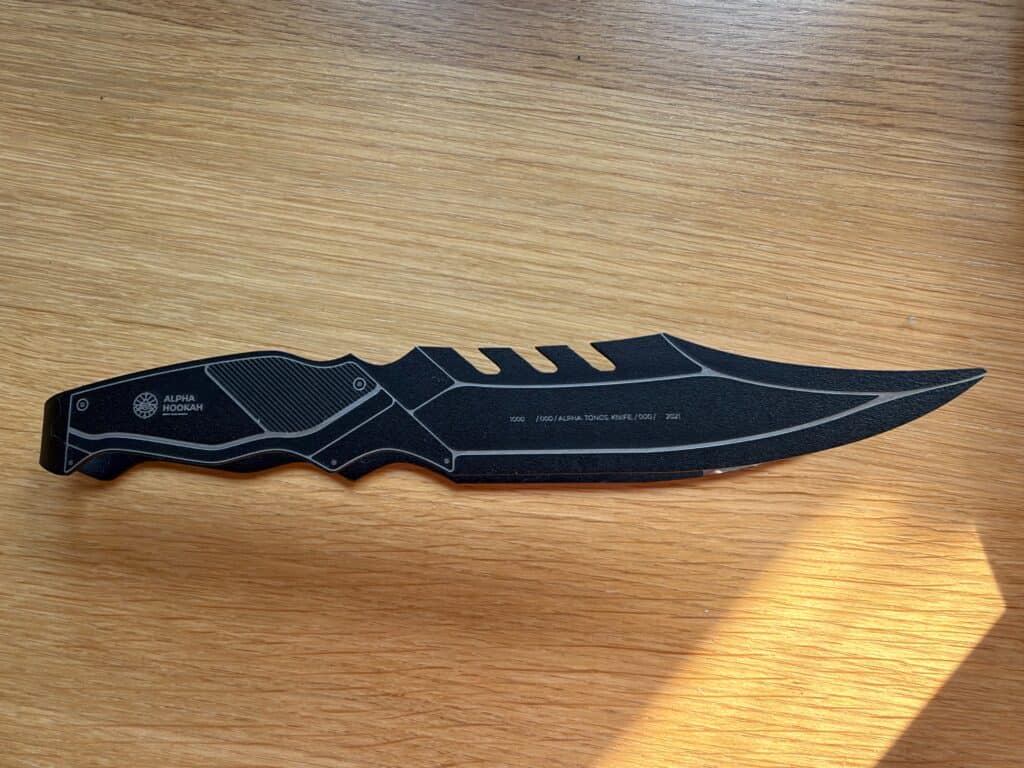 Schwarzes Messer mit Klinge auf Holztisch.